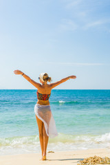young woman walking  on the beach