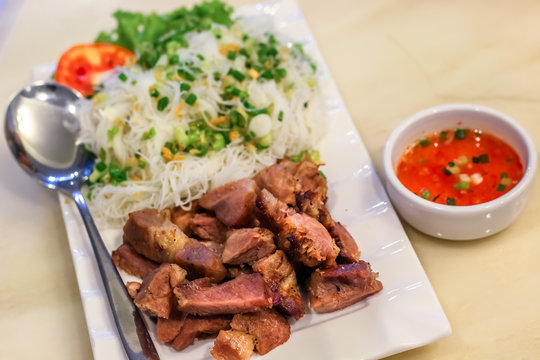 grilled pork with rice noodle in the white place with chilli dipping sauce