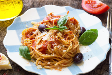 Spaghetti with tomato sauce on wooden background