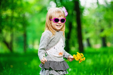 Little girl in sunglasses with flowers