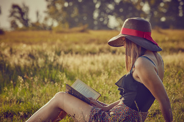 Giovane ragazza legge un libro in campagna