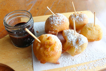 dessert made of fried banana ball with flour outside together with chocolate dip and icing on it