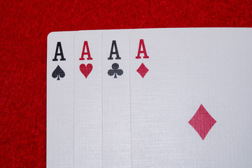Four aces - A winning poker hand of four aces playing cards suits on RED.
