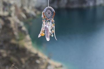 Handmade native american dream catcher on background of rocks an