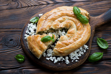 Burek stuffed with cheese and spinach in a rustic wooden setting