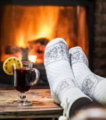 Warming and relaxing near fireplace with a cup of hot wine.