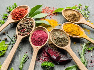 Assortment of colorful spices in the wooden spoons.