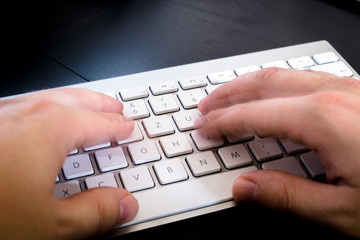 Männer Hände schreiben auf weißer Tastatur im Büro