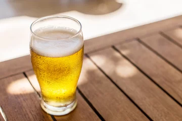 Fotobehang Glass of light beer on the wooden table. © volff