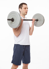 Young man doing exercises with barbell