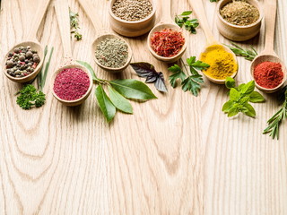 Assortment of colorful spices in the wooden spoons.