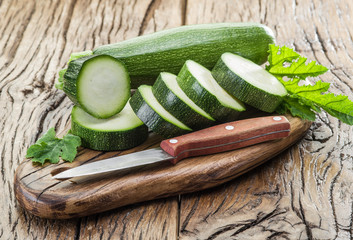 Zucchini with slices on a wooden table.