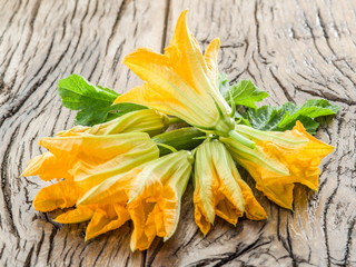 Zucchini flowers on a old wooden table.
