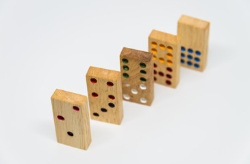 Sequence of wooden dominoes on white background with selective focus