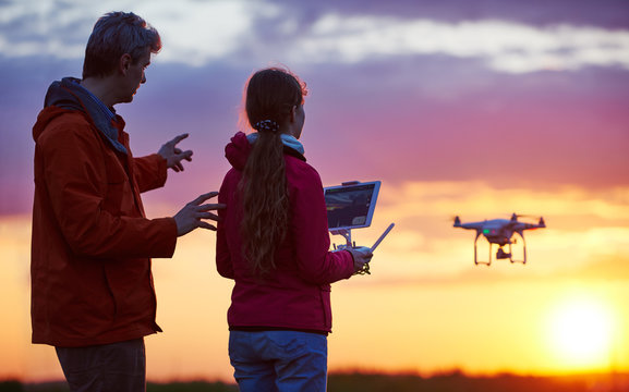 man operating of flying drone at sunset