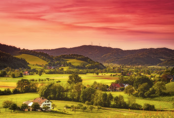 Obraz premium Scenic countryside landscape: summer mountain valley with forests, fields and old houses in Germany, Black Forest