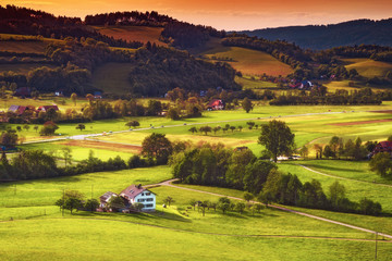 Scenic countryside landscape: green summer mountain valley with forests, fields and old houses in Germany, Black Forest