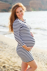 Pregnant woman on the sandy beach