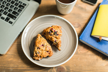 concept: workplace , computer, notebooks, home-made cakes