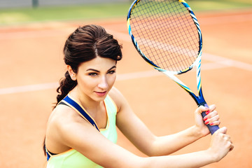 pretty young tennis player woman playing tennis. Female athlete wearing yellow sportswear