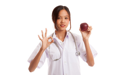 Young Asian female doctor show OK with apple  isolated on white background