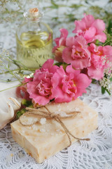 Natural handmade soap, aromatic oil and flowers on white wooden
