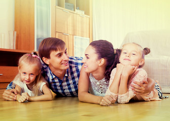 Obraz na płótnie Canvas Family values: portrait of parents with little girls indoors