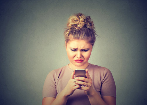 Sad upset woman using mobile phone