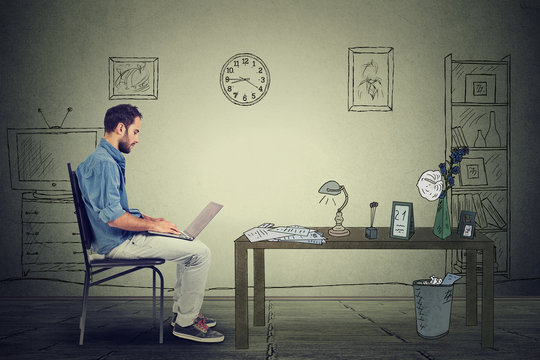 Side profile young man entrepreneur working on laptop in office sitting on chair