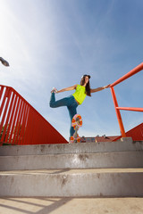 Teen girl skater riding skateboard on street.