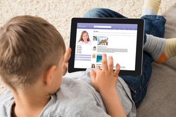 Boy Using Social Networking Site On Digital Tablet