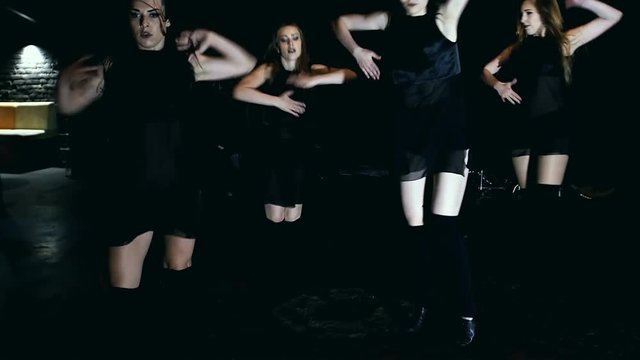 Contemporary dance performance of four dancers on dark