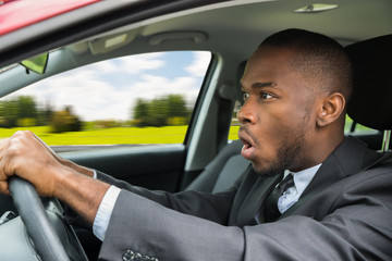 Shocked Businessman Driving Car