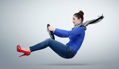 Young woman driver car with a wheel on background