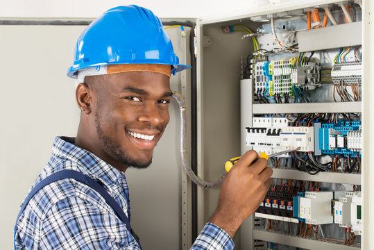 Technician Checking Fusebox With Screwdriver