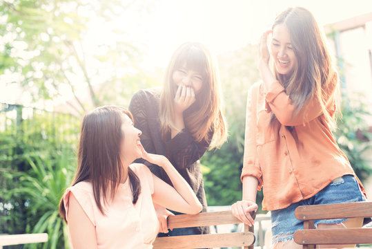 Three beautiful happy Asian girl smile and laugh together.Image with sunlight filter...