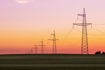 Landscape with power lines over sunset