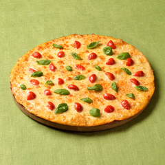 Pizza Margharita on green linen background