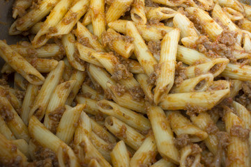 This is a photograph of Penne Pasta covered in Tomato sauce and ground beef