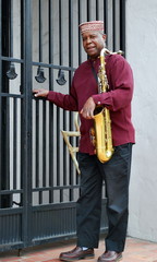 African american jazz saxophone player with his horn outdoors.