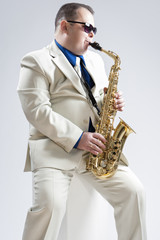 Fototapeta premium Music Concepts. Hadnsome Male Saxophone Player Playing in Studio