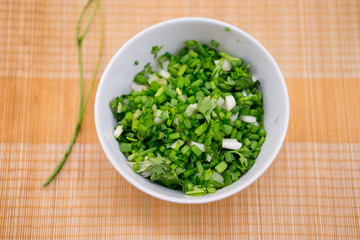 Obraz na płótnie Canvas chopped green onions and coriander in bowl