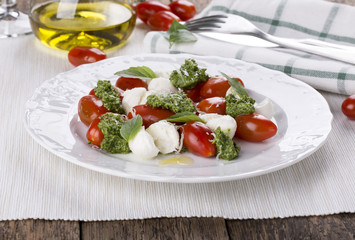Caprese. Italian salad - mozzarella, tomato, basil, pesto.