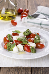 Caprese. Italian salad - mozzarella, tomato, basil, pesto.