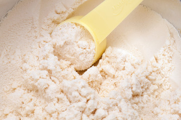 Fototapeta na wymiar close up of powdered milk and spoon for baby on white background