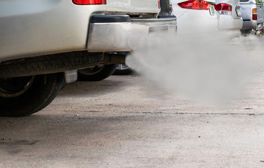combustion fumes coming out of car exhaust pipe