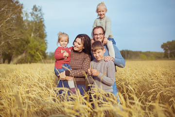 Happy family on a yellow agricultural field