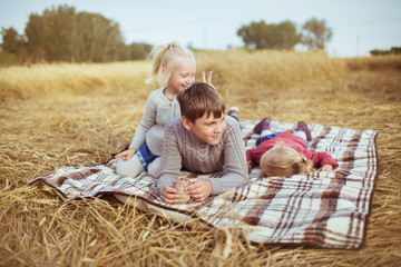 Children play on a plaid on a field