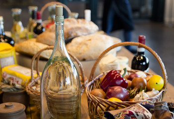 Basket of potatoes ready to be peeled with olive oil at hand