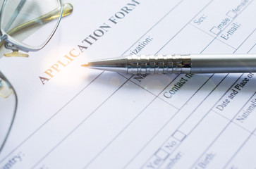 pen and glasses over application form